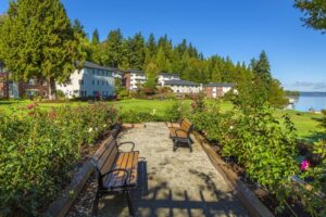 A walkway with benches in a flower garden